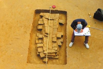 考古人員在對(duì)發(fā)掘出的“磚棺”進(jìn)行繪圖。市文物局供圖