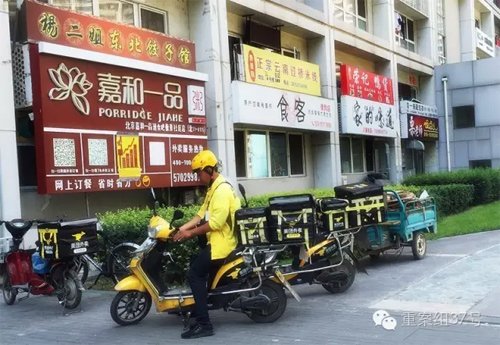 2016年7月26日，通州區(qū)北京像素小區(qū)，一棟樓的一樓開了密集的餐館，餐館外停著美團的外賣車，一名送餐員正要騎車去送餐。