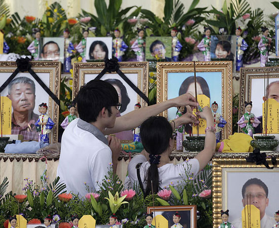 7月24日，臺(tái)灣澎湖，兩名親屬在遇難者的遺像前插香祭奠。