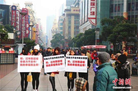 資料圖：2015年2月4日，幾位女青年手舉標(biāo)語出現(xiàn)在上海鬧市區(qū)，無聲地抗議親友的逼婚行為，其標(biāo)語上寫著“媽，過年回家別逼婚。我的幸福我主宰！”中新社發(fā) 章渝 攝 圖片來源：CNSPHOTO