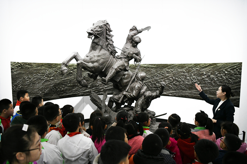 2019年4月4日，在東北烈士紀(jì)念館，學(xué)生們?cè)诼?tīng)講解員講解。