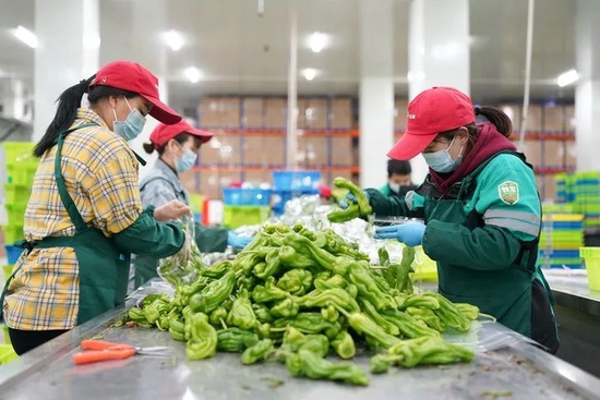 4月1日淩晨，工作人員在位於上海松江區(qū)的叮咚買菜蔬果大倉內(nèi)忙碌。新華社記者丁汀攝