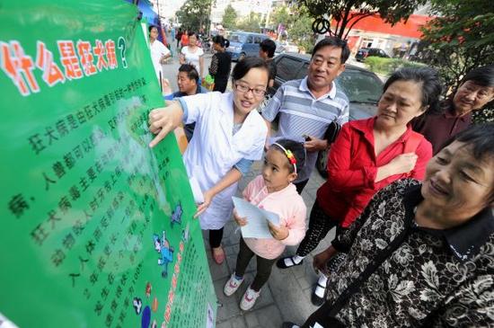 資料圖片：工作人員在街頭向居民講解狂犬病防治知識(shí)。 新華社記者杜宇攝