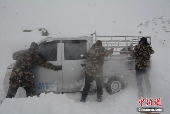 12日,新疆阿勒泰邊防官兵在救援被困車輛。(圖片來源:中新網(wǎng))