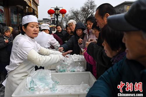 2017年2月7日，不少北京市民在一家傳統(tǒng)北京小吃店購買該店手工製作的傳統(tǒng)清真元宵。中新社記者 崔楠 攝